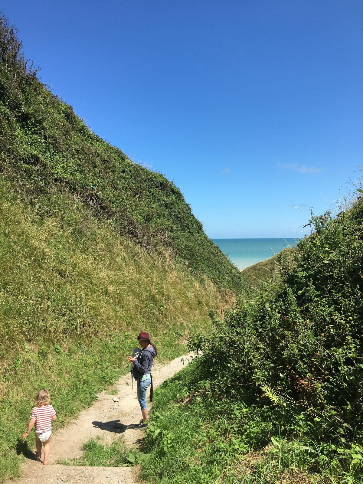 Familie wandert auf einem Küstenweg zum Meer